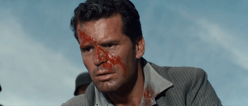 Close-up of Bob Hendley (James Garner) looking down at Colin Blythe (Donald Pleasance), with a distraught expression and blood on his face