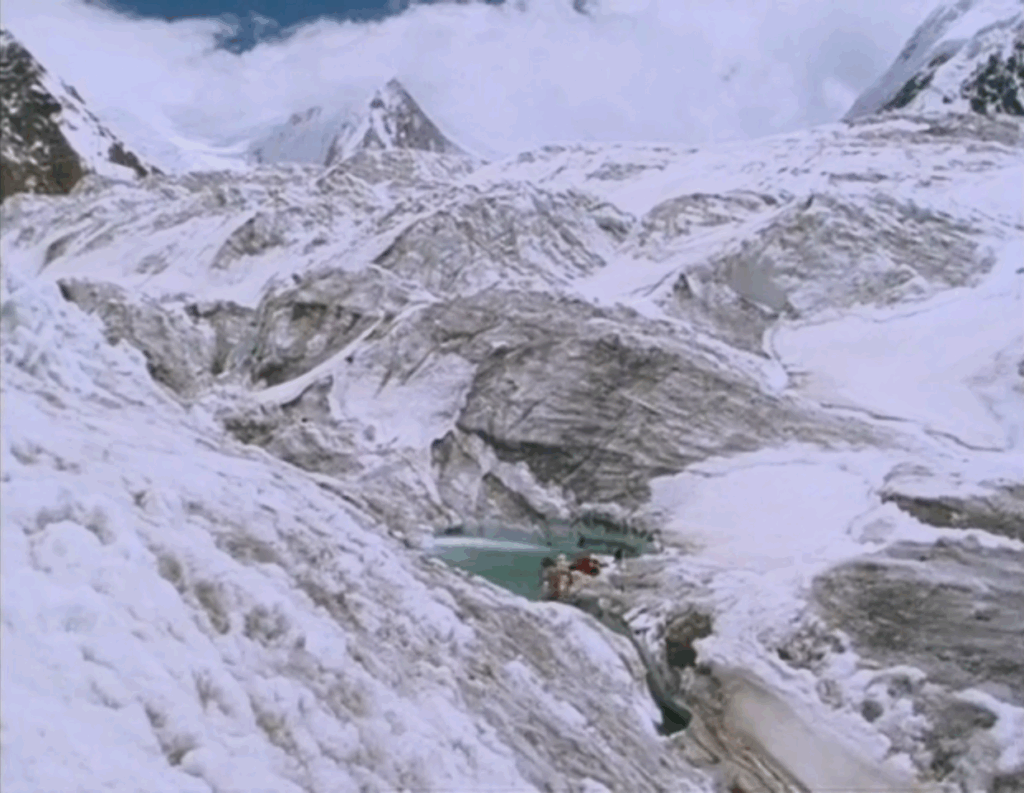A shot of Reinhold Messner in a mountain spring surrounded by picturesque snow covered mountains