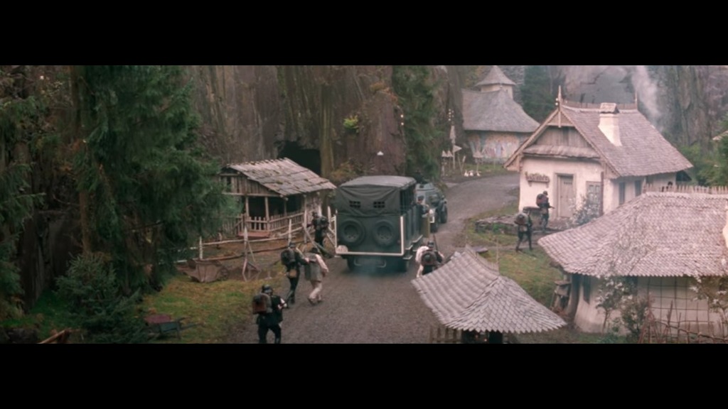 From the point of view of a Nazi vehicle, we see a dirt road, with a brightly painted church at the end.