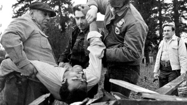 White militia members carry the corpse of Ben after shooting him