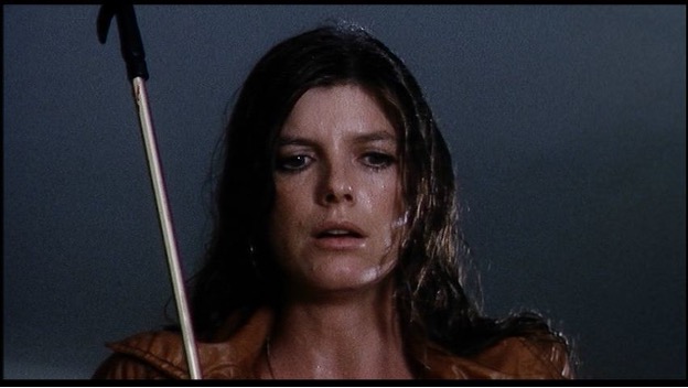 A woman stands in the rain.