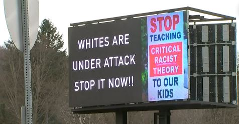 A billboard reads on one 'Whites are under attack stop it now!!!' and on the other, 'STOP teaching critical race theory to our kids.'