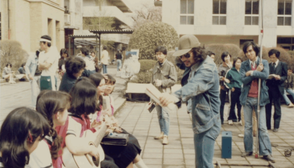 Nobuhiko Obayashi, on set of House, directing the main cast as they sit on the bench outside of their school.