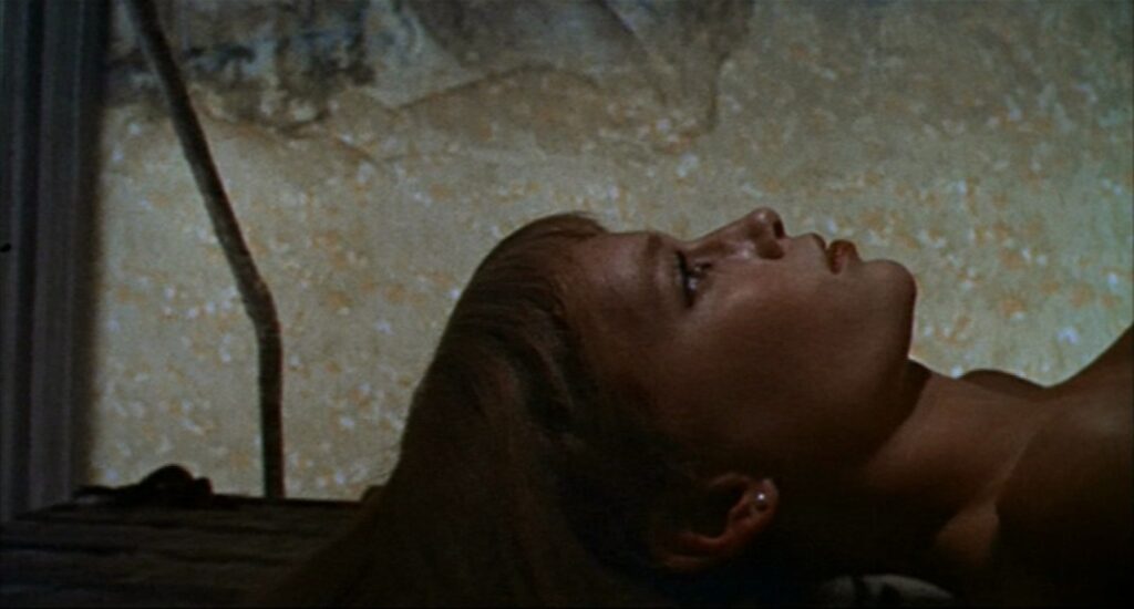 A close up of Rosemary lying on her back, looking at the ceiling, unclothed in the chamber.