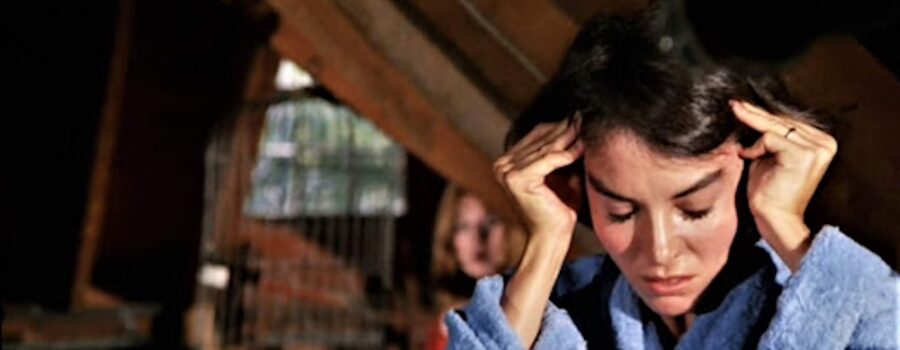A headache = a brunette woman rubbing her temples with both hands