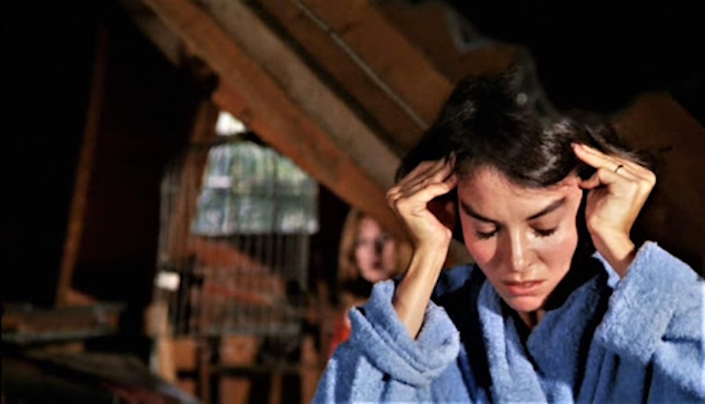 A headache = a brunette woman rubbing her temples with both hands.