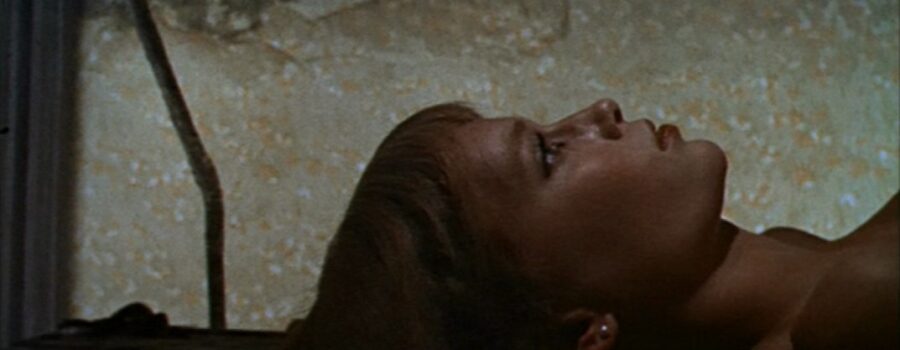 A close up of Rosemary lying on her back, looking at the ceiling, unclothed in the chamber.
