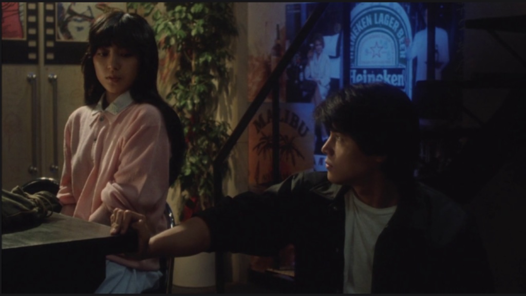 Koh looks at his ex-girlfriend Fuyumi, who is sitting at a bar.