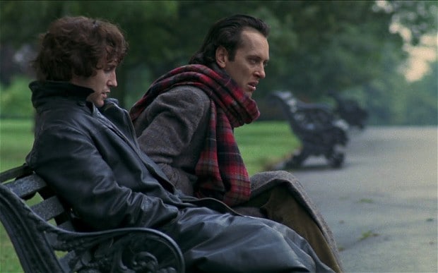 Marwood (Paul McGann) and Withnail (Richard E. Grant) sitting on a park bench.