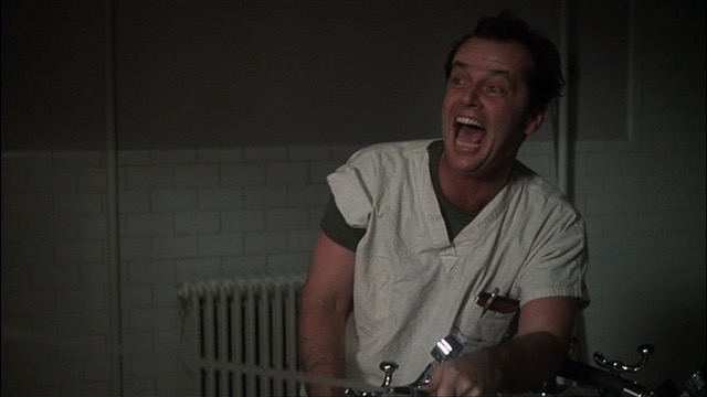 Randle Patrick McMurphy cackles wildly while he blasts his fellow inmates with a water hose 