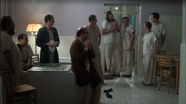 Ten men stand around a wash room, as Randle Patrick McMurphy is leaving. 