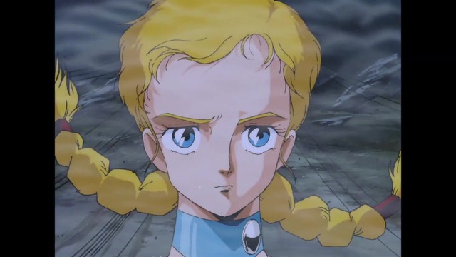 “Closeup of determined blond woman facing the viewer with decorative wrap on her neck.