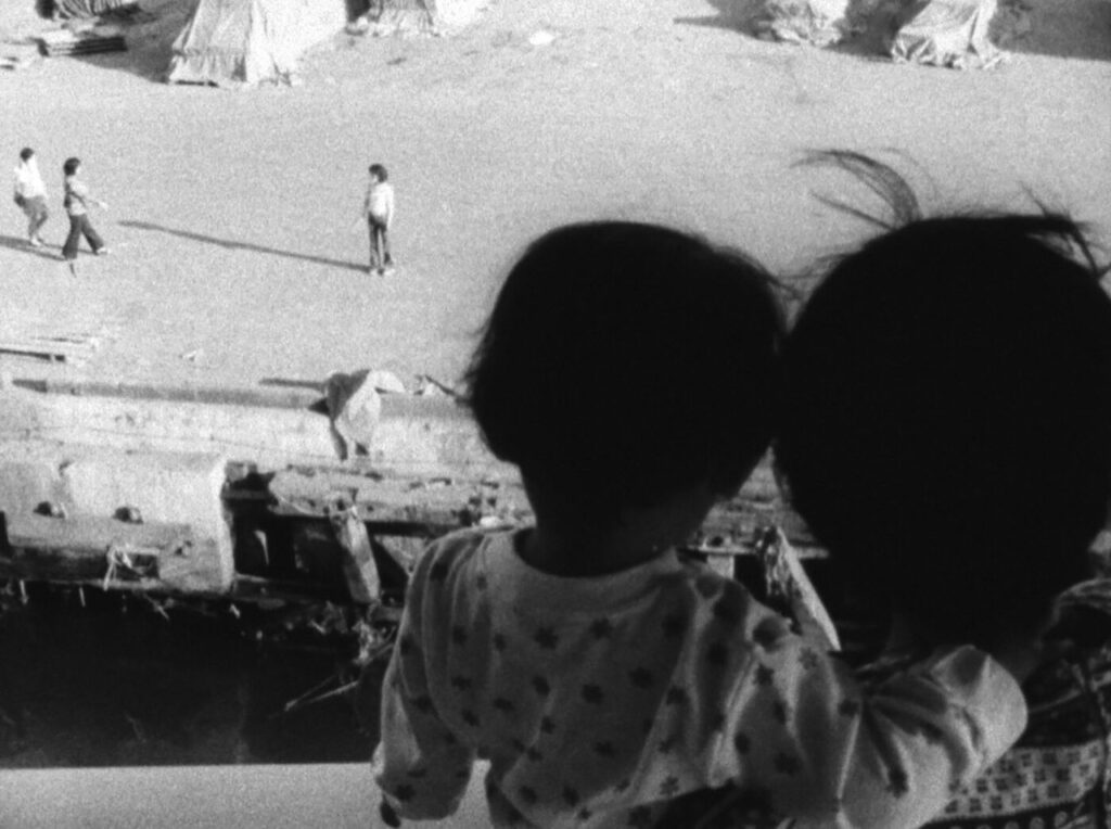 a woman and a child are facing away from the camera, sitting in a sports stadium.