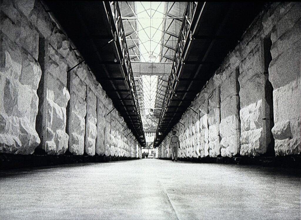 Wide-angle shot of a prison cell block with two tiers of cells.