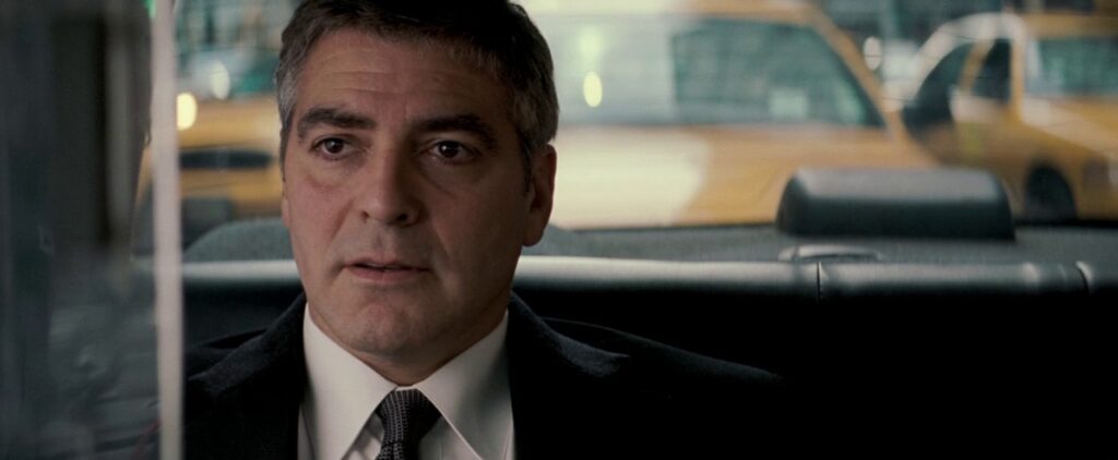 Michael Clayton (George Clooney) sits in the back of a New York Taxi, trailed by three other New York taxis, quietly considering the fallout of selling out his client to the police. 