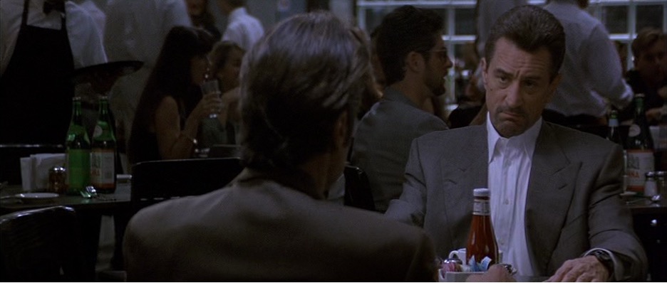 Two men sit in a coffee shop.