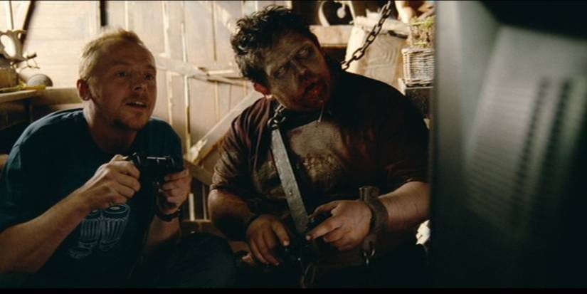 Shawn and zombified Ed play video games inside Shawn's shed. Ed is chained by the neck and wrists to keep him at bay.