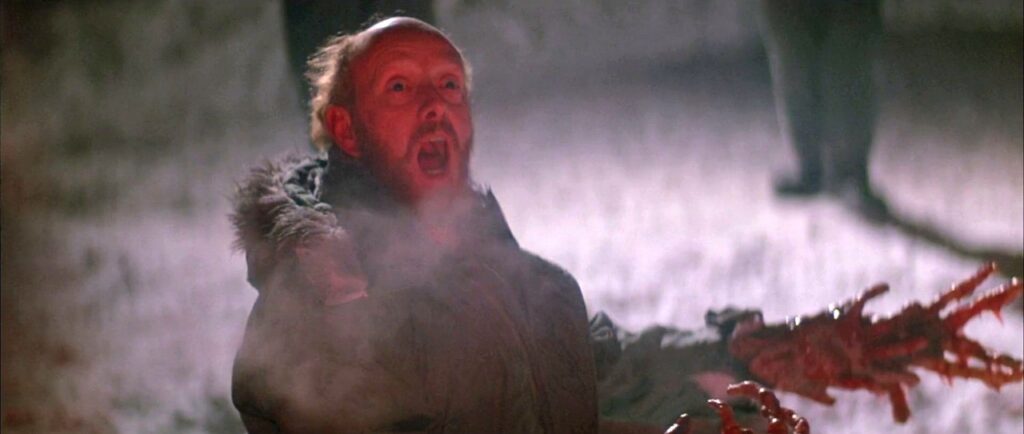 Peter Maloney as Bennings extends an alien altered hand right before he’s set on fire