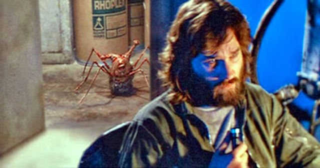 An alien spider-head creature scurries across the floor behind MacReady in the foreground.