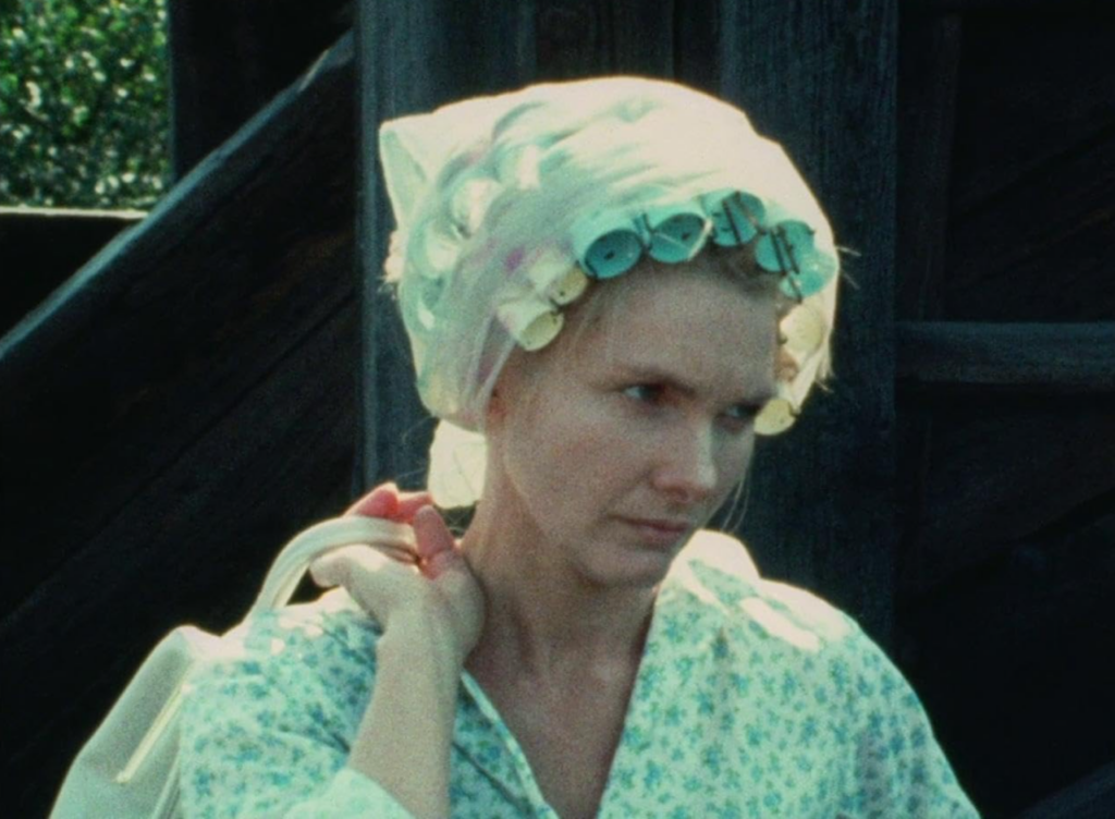 Up-close shot of Wanda outdoors with curlers in her hair.