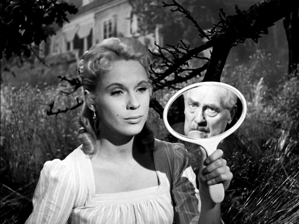 Sara (Bibi Anderson) holding a mirror up to show Isak’s (Victor Sjöström) face.
