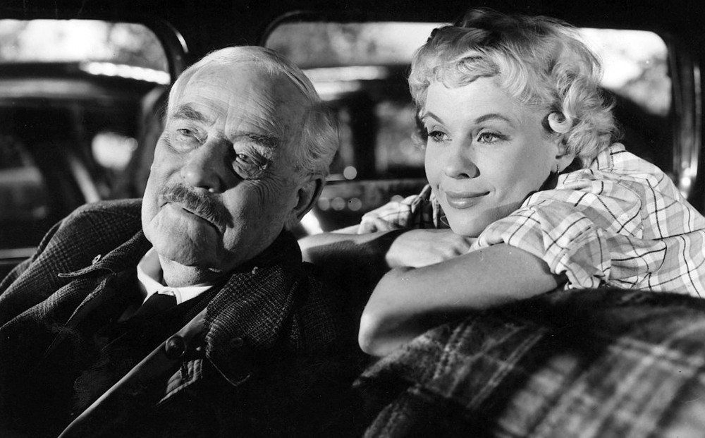 Isak Borg (Victor Sjöström) and one of the hitchhikers (Bibi Anderson) wait in the car.