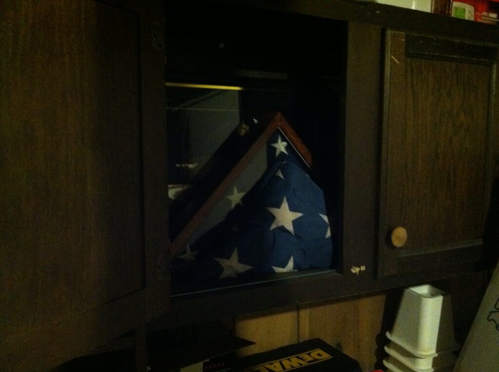 Inside the cabinet of the previous picture is a folded USA flag in a triangle form