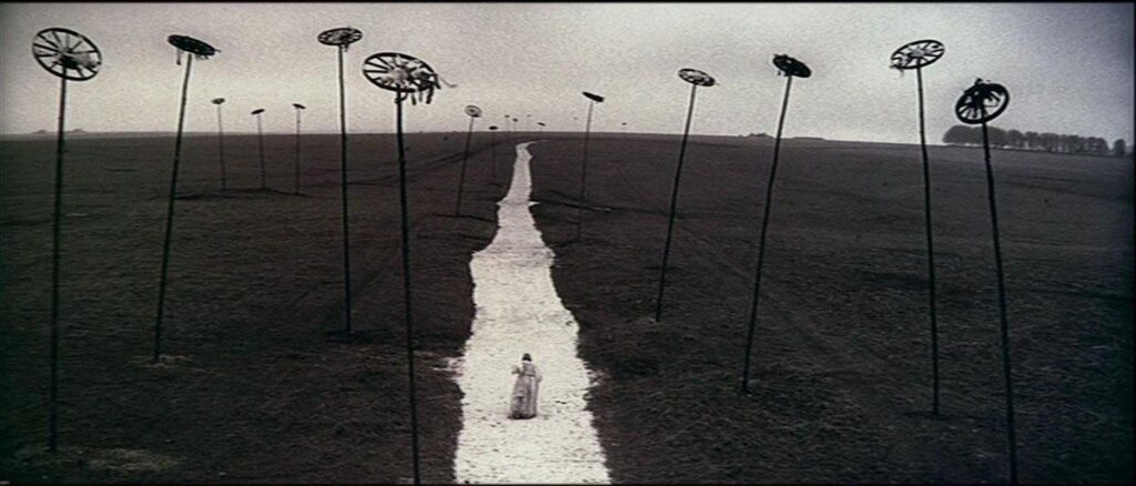 Madeleine (Gemma Jones) walking away from the ruins of Loudun.